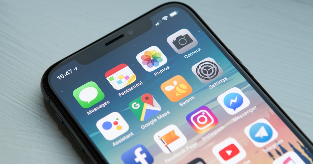 Smartphone affichant Google Maps, posé sur une table en bois clair